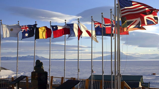 Flags of the original 12 signatory nations of the Antarctic Treaty fly next to a bust of Adm. Richard Byrd at McMurdo Station Oct. 21, 2005, in Antartica. 