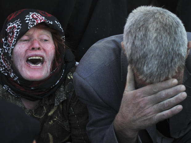 Iranian woman and man grieve after their loved ones were killed during Saturday's earthquakes  