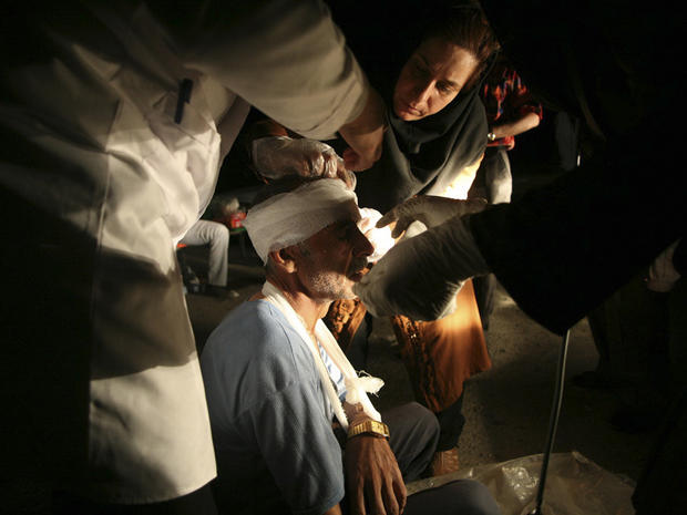 Medics treat an injured man after an earthquake in the city of Varzaqan 