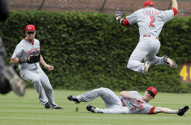 Ryan Ludwick, left, Drew Stubbs, bottom, and Zack Cozart (2) cannot make a play 