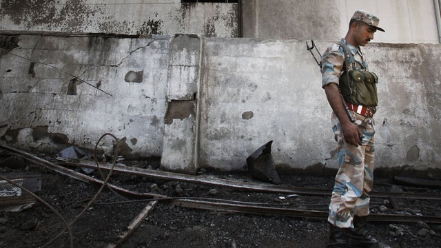 Syrian soldier investigates the scene of a bomb blast 