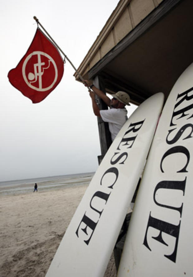 Lifeguard Duane Gonzalez takes down the red warning flag on a beach in Tampa 