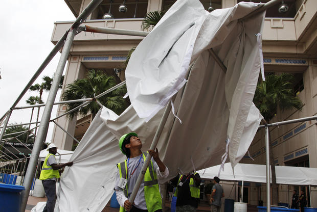 Joel Jimenez, right, and Issac Page remove an awning outside the Tampa Convention Center 