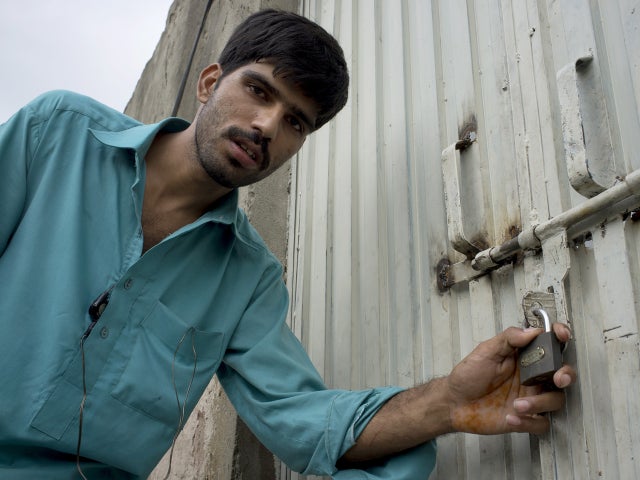 A Muslim neighbor of an arrested Christian girl shows the lock on her house 