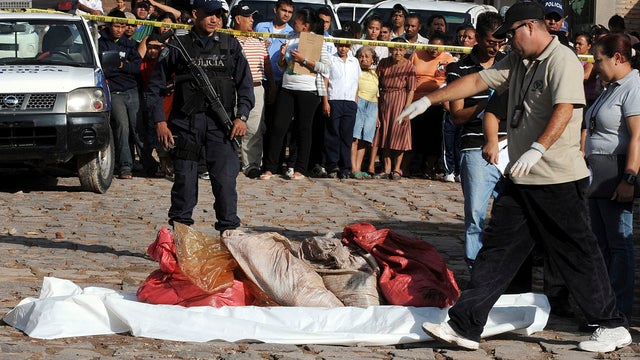 Police investigators gather bags containing body parts in the capital city of Tegucigalpa 