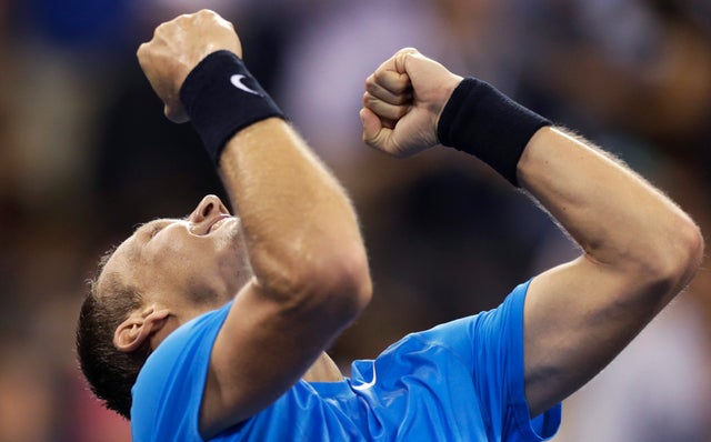 Tomas Berdych raises his arms after beating Roger Federer 