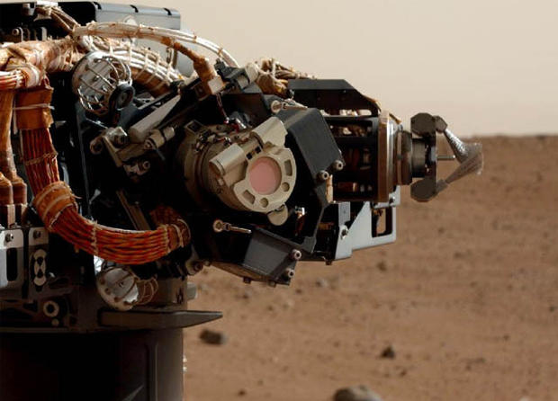 The left eye of the Mast Camera (Mastcam) on NASA's Mars rover Curiosity took this image of the camera on the rover's arm, the Mars Hand Lens Imager (MAHLI), during the 30th Martian day, or sol, of the rover's mission on Mars (Sept. 5, 2012). MAHLI is one of the tools on a turret at the end of the rover's robotic arm. When this image was taken, the arm had raised the turret to about the same height as the camera on the mast. 