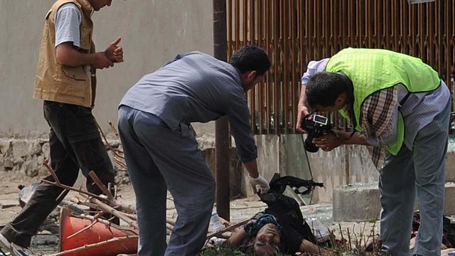 Afghan investigators inspect remains of suicide attack victim in Kabul Saturday  