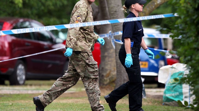 A member of the Royal Logistic Corps bomb disposal team walks with a police officer Sept. 10, 2012, close to the Claygate, England, home of Saad al-Hilli, who was shot dead with three others while vacationing in the French Alps. 
