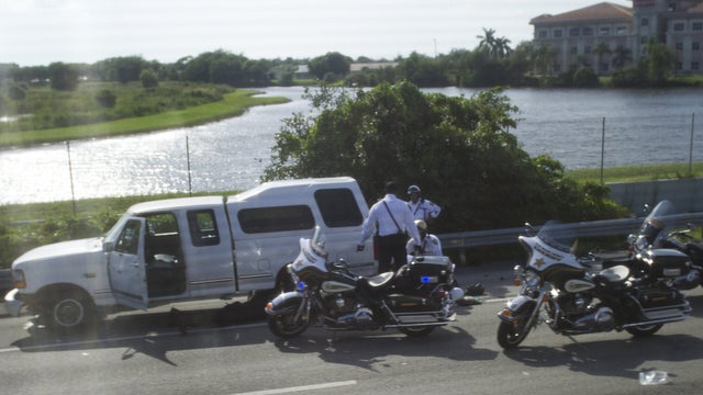 Police officers tend to injured Jupiter Police Department motorcycle officer Sunday 