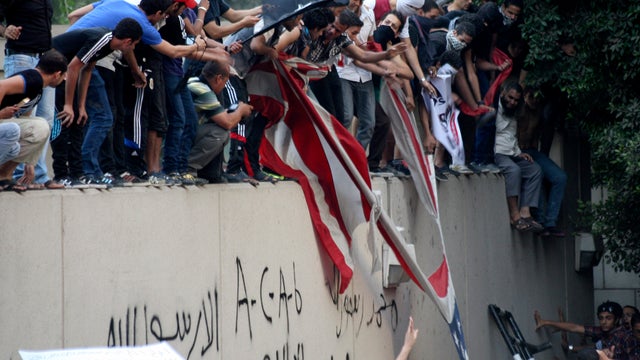 Protesters destroy an American flag pulled down from the U.S. Embassy in Cairo Sept. 11, 2012. 