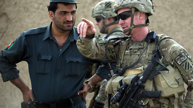 Army Lt. Jameson Bligh, right, talks with an officer from the Afghan National Police at a settlement near Kandahar Air Field Sept. 12, 2012. 