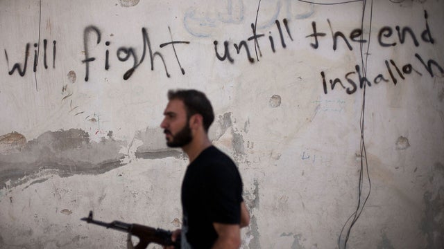 An FSA soldier walks through a street in Amariya district in Aleppo 