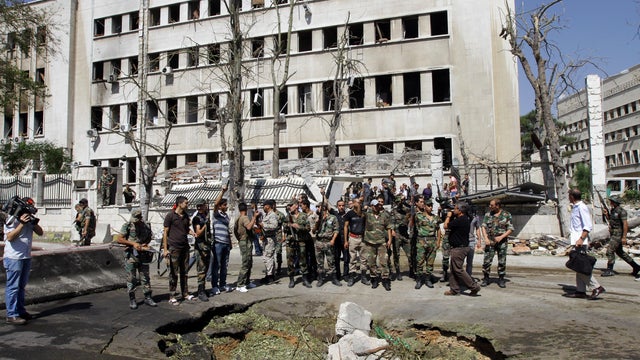 Syrian soldiers stand at the site of twin bombings near the headquarters of the armed forces general staff in Damascus 