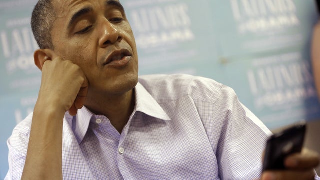 President Barack Obama uses a cell phone to call supporters during a visit to a local campaign office, Monday, Oct. 1, 2012 in Henderson, Nev. 