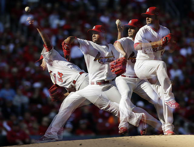 Cincinnati Reds second baseman Brandon Phillips, top, turns the double-play  as the St. Louis Cardinals' David Freese tries to break it up in the second  inning at Busch Stadium in St. Louis