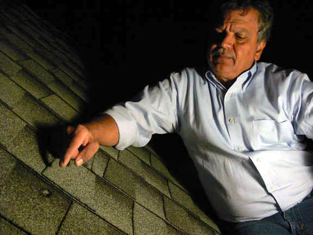 The dent in a roof caused by a meteorite from the Oct. 17, 2012, fireball over Northern California is identified by Luis Rivera, the neighbor of Lisa Webber who found the meteorite after it struck her Novata, Calif., home. 