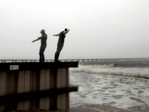Jessica Ospina, left, and Allison Kane of Virginia Beach, Va., lean into the strong wind and rain off the Chesapeake Bay near the Chesapeake Bay Bridge tunnel in Virginia Beach as Hurricane Sandy works its way north, battering the U.S. East Coast Oct. 28, 