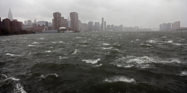 A person walks along the bank of the East River ahead of Hurricane Sandy  