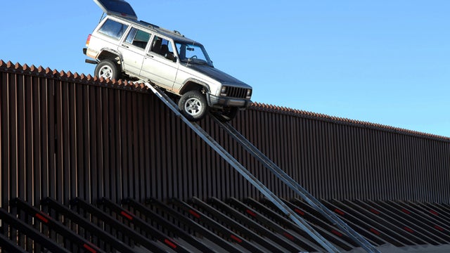 A silver Jeep Cherokee that suspected smugglers were attempting to drive over the U.S.-Mexico border fence is stuck at the top of a makeshift ramp Oct. 31, 2012, near Yuma, Ariz., in this picture provided by the U.S. Customs and Border Protection agency. 