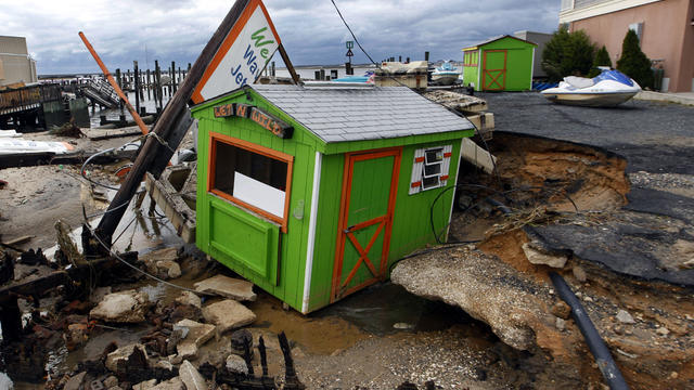 A small shop that rents personal watercraft rests in a huge sinkhole on the bayside in Ocean City, N.J., Oct. 30, 2012, after a storm surge from superstorm Sandy the night before. 