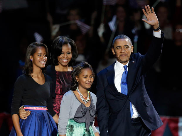 President Barack Obama waves as he walks on stage with first lady Michelle Obama and daughters Malia and Sash 