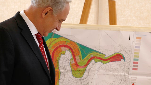 Israeli Prime Minister Benjamin Netanyahu looks at a map of the area marked for the construction of new housing units in East Jerusalem 