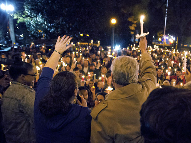 Ole Miss Chancellor Dan Jones, right, and others raise their candles during the "We are One Mississippi" candlelight walk on the campus of the University of Mississippi in Oxford, Miss., Nov. 7, 2012. The walk was organized to condemn an election night protest against the re-election of President Obama. 