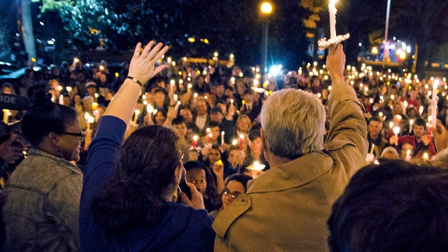 Ole Miss Chancellor Dan Jones, right, and others raise their candles during the "We are One Mississippi" candlelight walk on the campus of the University of Mississippi in Oxford, Miss., Nov. 7, 2012. The walk was organized to condemn an election night pr 