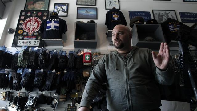 Extreme far-right Golden Dawn party lawmaker Ilias Panagiotaros speaks in his shop in central Athens 
