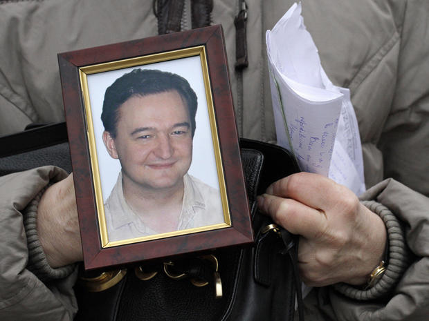 A portrait of lawyer Sergei Magnitsky who died in jail, is held by his mother Nataliya Magnitskaya 