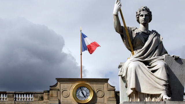 A picture taken in Paris on June 18, 2012, shows a statue and the French national flag 