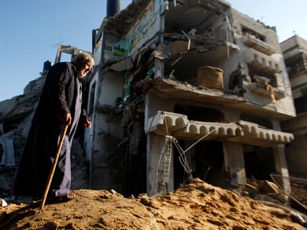 An elderly Palestinian man walks next to a destroyed building after an Israeli strike in Gaza City Nov. 20, 2012.