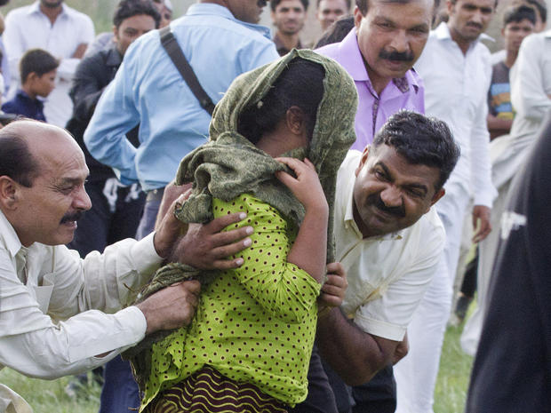 A young Christian girl accused of blasphemy is escorted to a helicopter after her release from prison 
