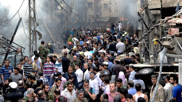 Syrians stand at the scene of an explosion in the Mazzeh al-Jabal district of Damascus 