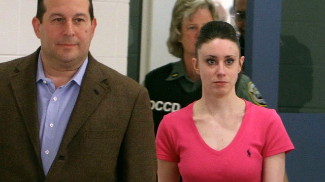 Casey Anthony holds hands with her defense attorneys, Jose Baez, left, and Dorothy Clay Sims, as they listen to the verdict 