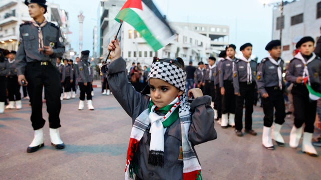 Palestinian girl waves a flag at a rally in Ramallahm, West Bank 