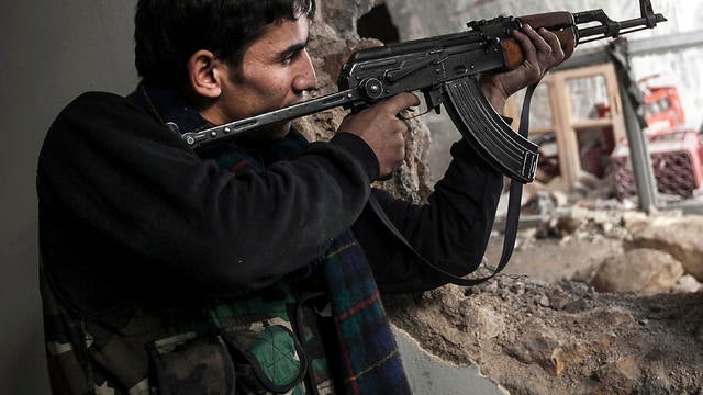 A Free Syrian Army fighter aims his weapon during clashes with government forces in Aleppo, Syria, Dec. 2, 2012. 