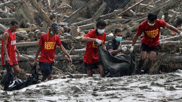Rescuers retrieve flash flood victims from the debris of Typhoon Bopha 