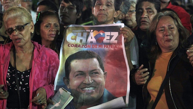 People, one holding an image of Venezuelan President Hugo Chavez, gather to pray for him at Simon Bolivar square in Caracas, Venezuela on Dec. 11, 2012. 