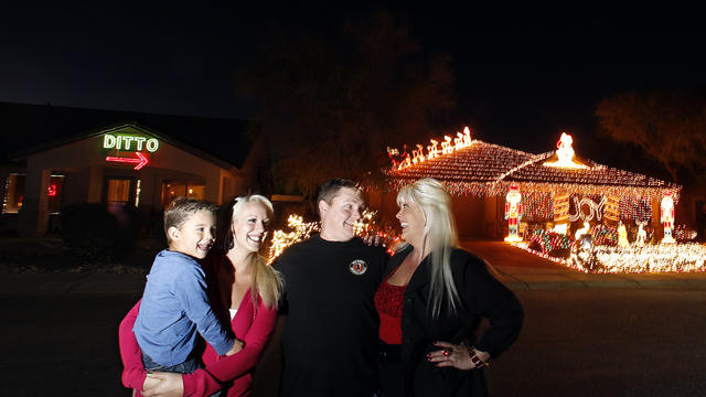 Kristina Green, right, her daughter Breanah Gray, second left, and grandson Cameron Gray, left, laugh together with neighbor Eric Cyr as they pose in front of their homes Dec. 11, 2012, in Maricopa, Ariz. 