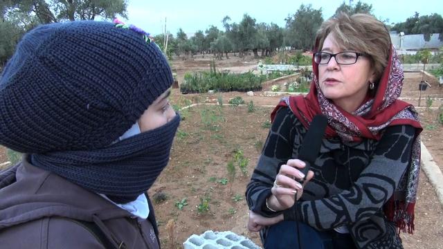 CBS News correspondent Elizabeth Palmer interviews a Syrian opposition activist, Sara, who covers her face to protect herself from backlash from the Syrian Army 