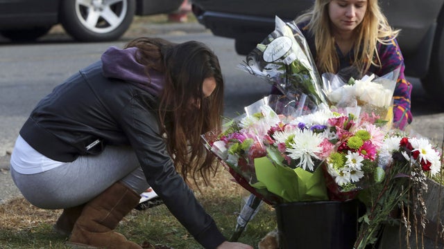 Ryan Bartolotta, 17, right, and Ray Massi, 18, light up candles that were put out by rain at a makeshift memorial in the Sandy Hook Village of Newtown, Conn., Dec. 17, 2012, as the town mourns victims killed in a school shooting. 