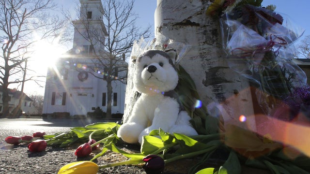 A child looks out of a bus window as it passes by St. Rose of Lima Catholic Church, where the funeral of James Mattioli, 6, was taking place Dec. 18, 2012, in Newtown, Conn. 