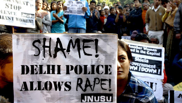 An Indian woman along with the others participates in a protest condemning the gang rape of a 23-year-old student on a city bus late Sunday in New Delhi, India, Tuesday, Dec. 18, 2012. 
