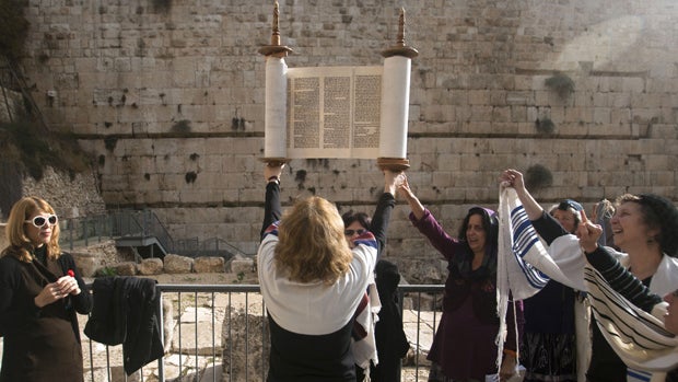 Israeli women of the Women of the Wall organization hold a Torah scroll during a prayer just outside the Western Wall, the holiest site where Jews can pray in Jerusalem's old city, Friday, Dec. 14, 2012. The shawls they are wearing are only worn by men in 