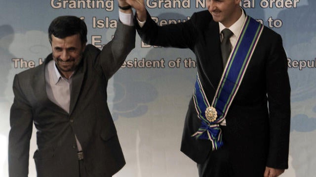 Iranian President Mahmoud Ahmadinejad (L) raises the hand of Syrian counterpart Bashar Assad  