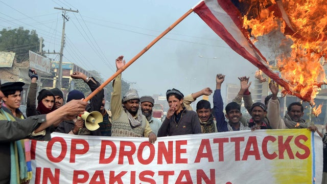 Pakistani demonstrators burn a U.S. flag during a protest against drone strikes 