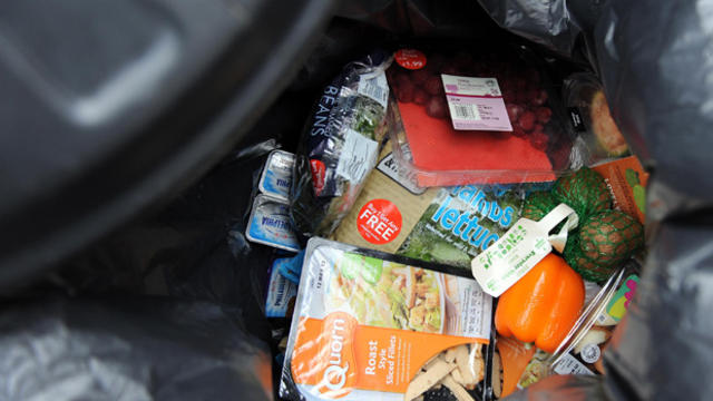 Out-of-date and unopened food from a household is thrown away in a dustbin. 