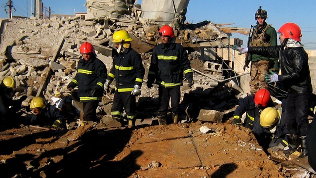 Fire fighters look for survivors at the local headquarters of the Kurdistan Democratic Party after a bomb attack  